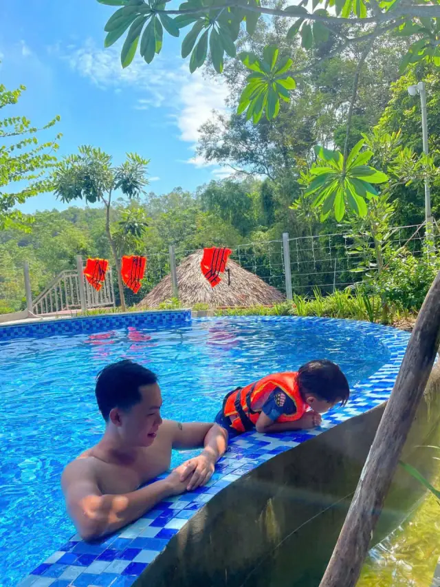 Bố và con trai nghịch nước ở bể bơi giữa vườn Sơn Thủy Retreat