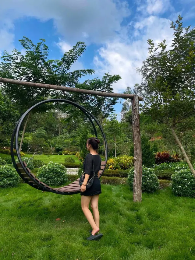 Cô gái đứng cạnh khung tròn bằng gỗ giữa thảm cỏ xanh trong vườn Sơn Thủy Retreat
