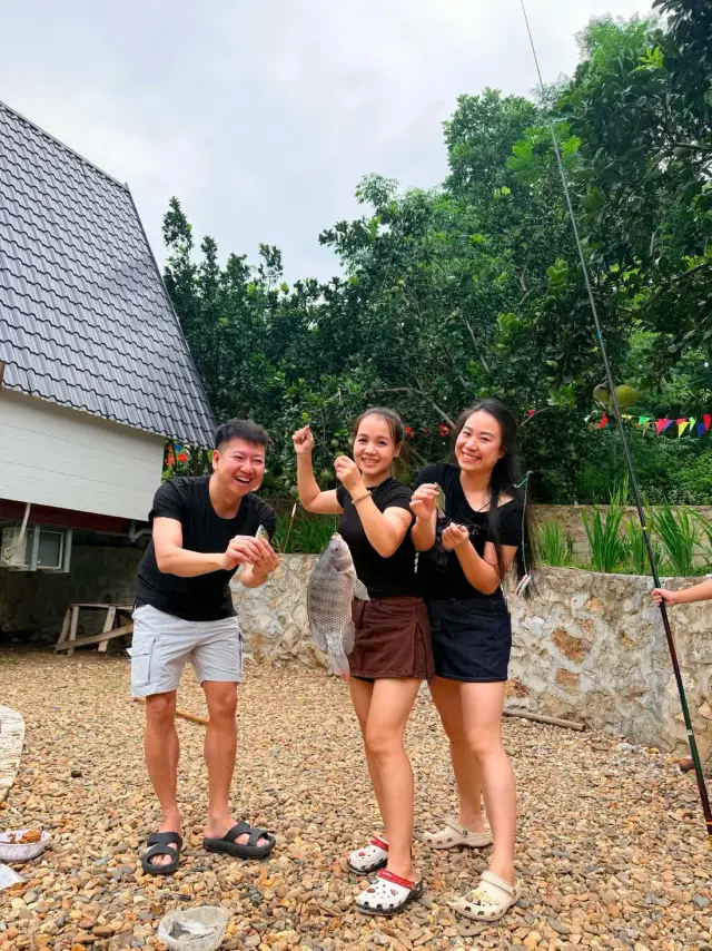 Nhóm ba người bạn cười vui giữa sân sỏi trước nhà mái chữ A, Sơn Thủy Retreat