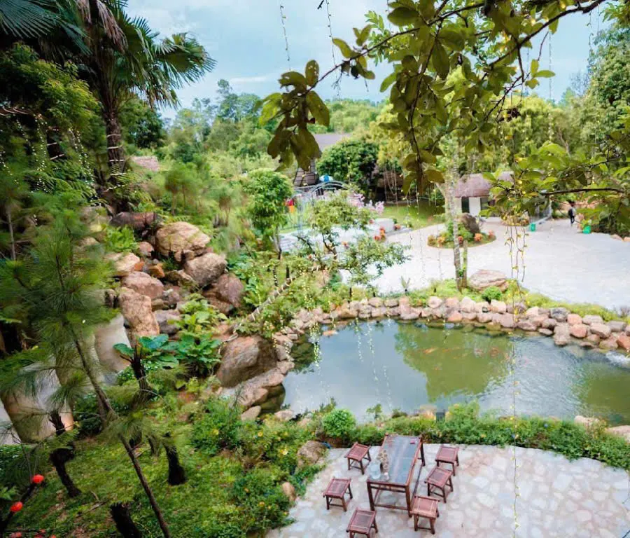 Vườn đá và hồ nước nhìn từ trên cao, lối đi lát đá trắng và bộ bàn ghế gỗ nhỏ